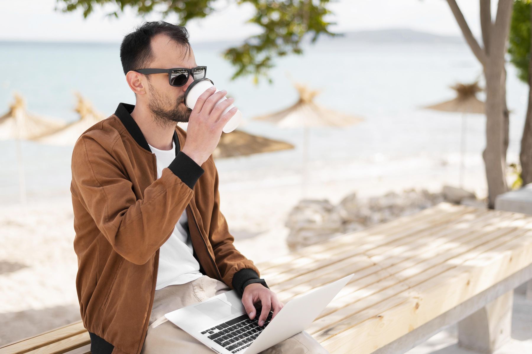 Man working on a laptop at the beach