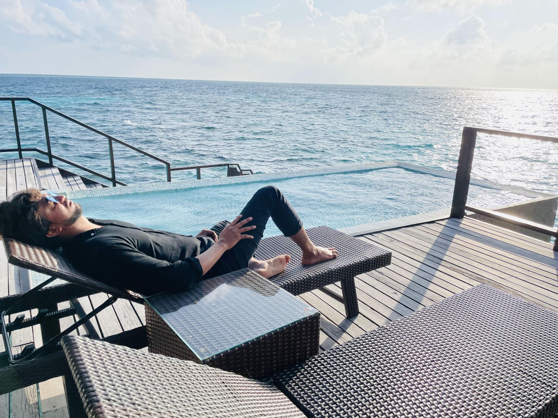Man relaxing by an overwater pool