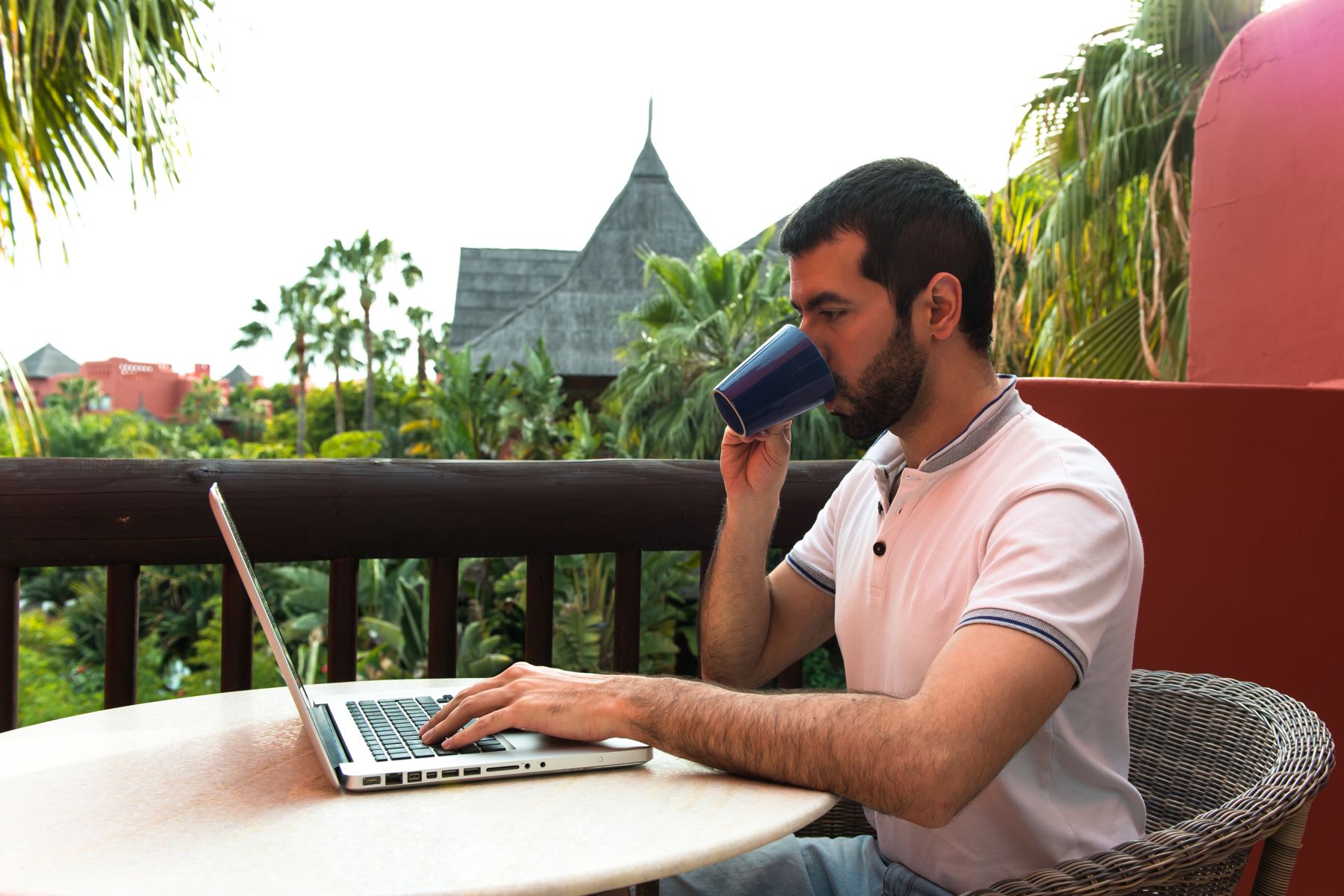 Man working on a laptop on a hotel terrace